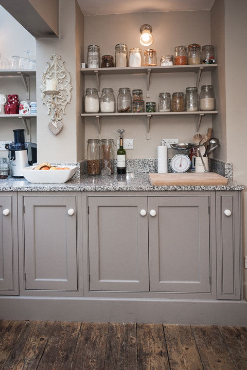 Photo of kitchen units and shelves stacked with glass jars in Victorian kitchen cottage design project Devon